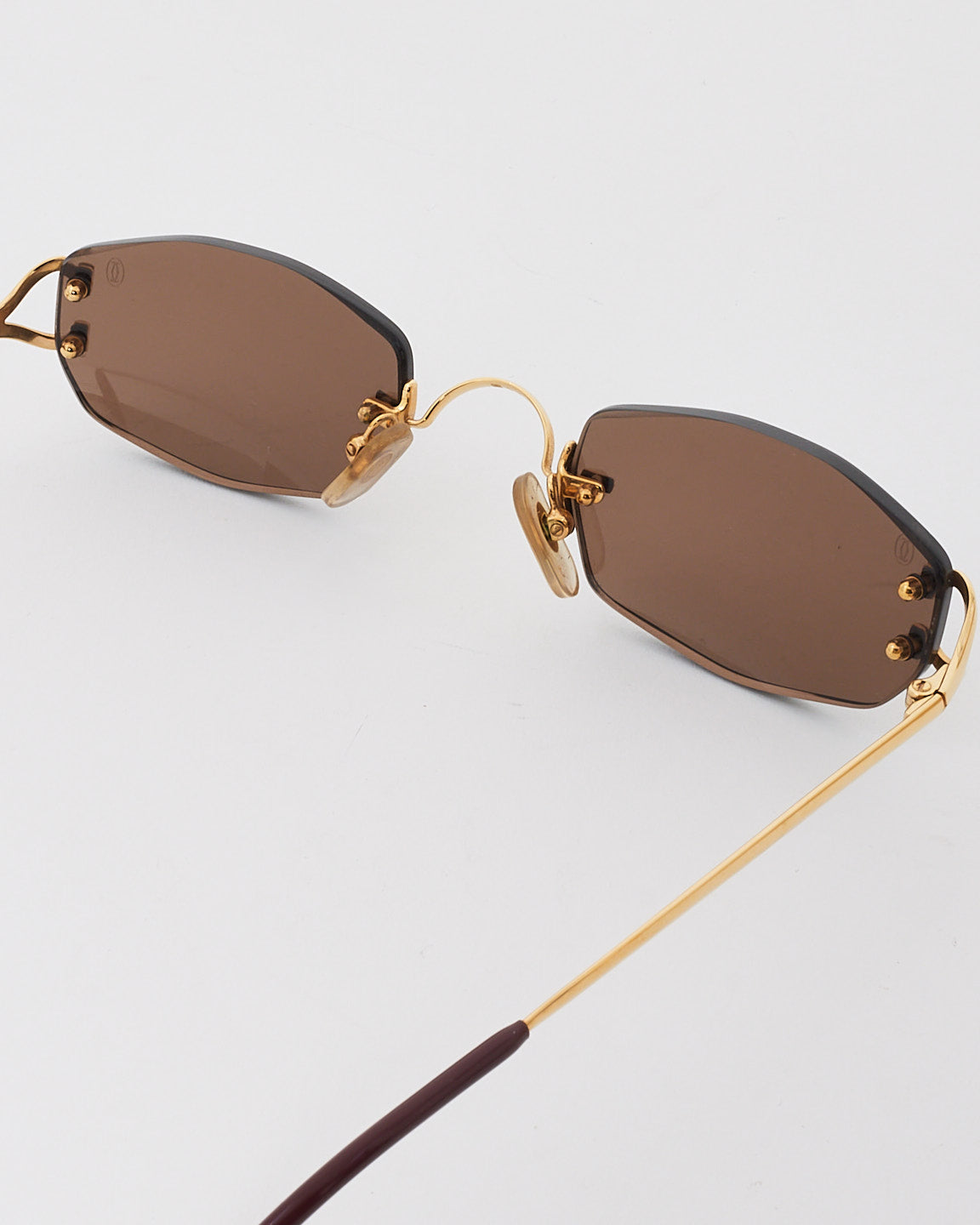 Cartier Petites lunettes de soleil sans monture à verres rectangulaires dorés et noirs